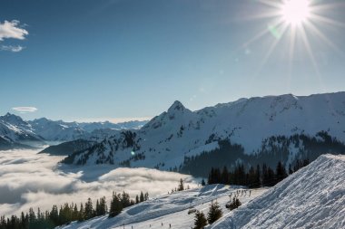 Kar ve dağlar ve sis vadide üst kısmında güneş