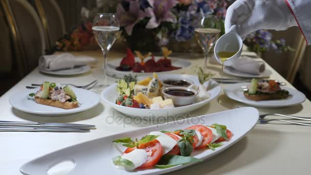 Alimentation saine et concept végétarien. Fermer Verser l'huile d'olive sur la salade de caprese. Salade de caprese italienne au fromage Mozzarella. Mouvement lent 