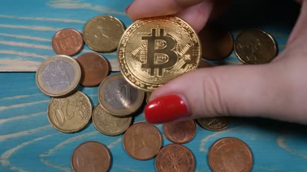 Worldwide virtual internet cryptocurrency and digital payment system. Female hand puts symbol of bitcoin on euro coins. Future economy. Shot in 4k — Stock Video