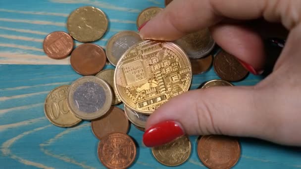 Dans le monde entier crypto-monnaie Internet virtuel et système de paiement numérique. Main féminine tourne symbole de Bitcoin avec les doigts et le met sur les pièces en euros. La future économie. Tourné en 4k — Video