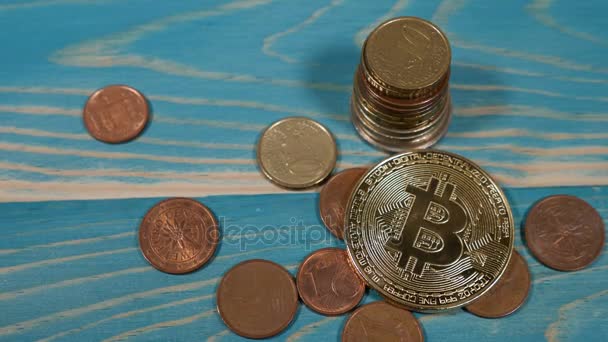 Dans le monde entier crypto-monnaie Internet virtuel et système de paiement numérique. Symbole de Bitcoin au-dessus des pièces en euros sur fond en bois. les pièces en euros sont en pile. Un doigt féminin touche les pièces. tourné en 4 k — Video