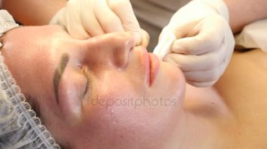 Güzellik Kliniği kavramı. Ten welness yakın çekim yapma botox enjeksiyon için kadın dudaklar eller. Genç kadın yüz enjeksiyon etmek alır... Yüz gençleştirme. 4k