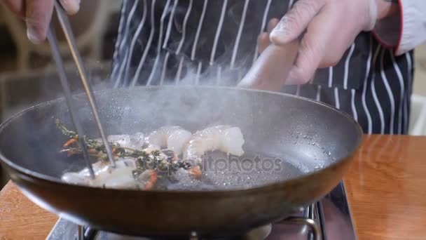 Närbild av en kock som förbereder flamberade stil maträtt på en Pan. Slow motion. Olja och alkohol antända med öppna lågor. Matlagning tiger räkor. Sköt i 4k — Stockvideo