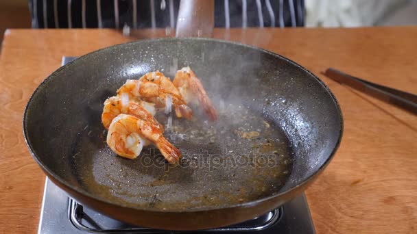 Primer plano de un chef que prepara un plato estilo Flambe en una sartén. En cámara lenta. El aceite y el alcohol se encienden con llamas abiertas. Cocinar camarones tigre. Disparo en 4k — Vídeos de Stock