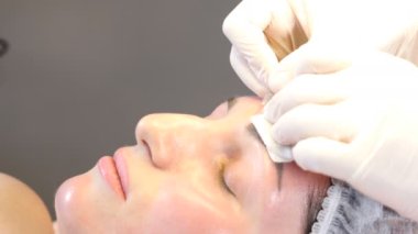 Güzellik kliniği. Eldiven giymiş güzellik uzmanları kadın derisine yüz yaşlanma enjeksiyonu yapıyor. Bir kadın güzellik yüz kozmetolojisi prosedürünü uygular. Botoks. Kolajen enjeksiyonları. 4K 'da çekilmiş.