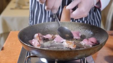 Şef yemek Flambe tarzı ile yemek restoran sıcak bir tava üzerinde karaciğer dilim close-up. Kaşıkla karıştırarak. Ağır çekim.