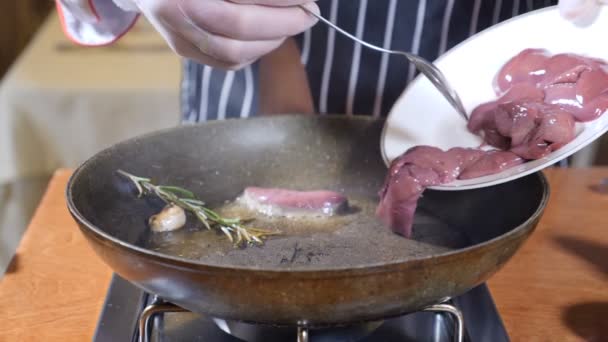 Close-up van chef-kok koken geflambeerd stijl schotel met plakjes lever op een hete koekenpan in restaurant. Segmenten van de lever zetten pan. Slow motion. — Stockvideo
