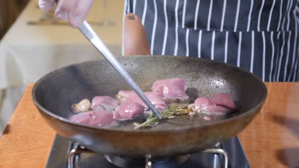 Close-up van chef-kok koken geflambeerd stijl schotel met plakjes lever op een hete koekenpan in restaurant. Slow motion. — Stockvideo