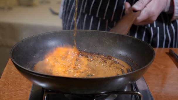 Koken restaurantconcept. Chef-kok in handschoenen kookt flamberen pannenkoeken in karamel. Vlam. Brand, Slow motion. — Stockvideo