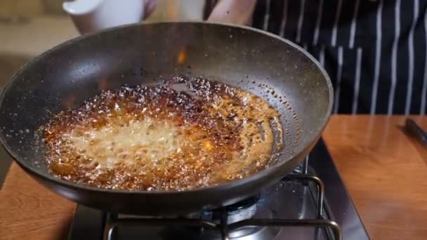 Concetto di cucina ristorante. Lo chef in guanti cucina frittelle di flambe in caramello. Fiamma. Fuoco, rallentamento . — Video Stock