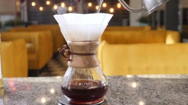 Modern ve alternatif yollar kahve yapma. Barista brews kahve kahve makinesi Chemeks kullanarak. Eller sıcak su içine kağıt filtre kahve ile dışarı pot dökme kapatın. Ağır çekim