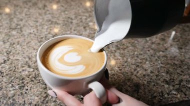 Kahve yapma. Barista kahve hazırlar. Latte hazırlanması. Barista sıcak süt espresso fincan dökme. Latte sanat. Ağır çekim