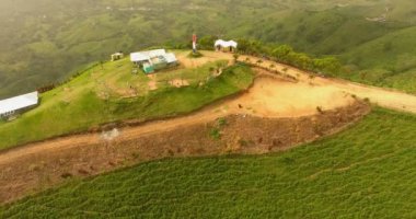Hava dron kuşlar göz görüş video ile yeşil çim kaplı bir dağ. Dağın tepesinde bir çiftlik var. tropik cennet Pasifik atoll Adaları. Üstten Görünüm. 4 k'dan fazla vurdu