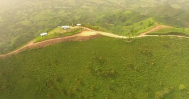 Hava dron kuşlar göz görüş video ile yeşil çim kaplı bir dağ. Dağın tepesinde bir çiftlik var. tropik cennet Pasifik atoll Adaları. Üstten Görünüm. 4 k'dan fazla vurdu