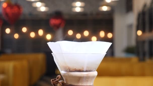 Moderne und alternative Möglichkeiten der Kaffeezubereitung.barista brüht Kaffee mit Kaffeemaschine Chemex. Nahaufnahme von Dampf aus Papierfiltern. Zeitlupe — Stockvideo