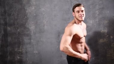 Güçlü ve kas adam vücut geliştiricisi. Adam siyah bir arka plan üzerinde poz kasları yanına bir not yazmak için boş alanı işaret gösterir. güzel Abs ve göğüs kasları.