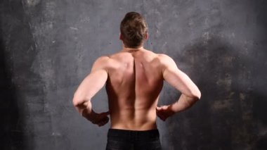 Sırtı ile poz güçlü ve kas adam vücut geliştiricisi. 4 k'dan fazla vurdu