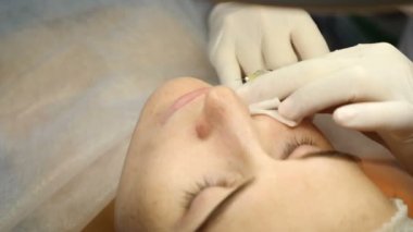 Güzellik kliniği. Eldiven giymiş güzellik uzmanları kadın derisine yüz yaşlanma enjeksiyonu yapıyor. Bir kadın güzellik yüz kozmetolojisi prosedürünü uygular. Botoks. Kolajen enjeksiyonları. 4K 'da çekilmiş.