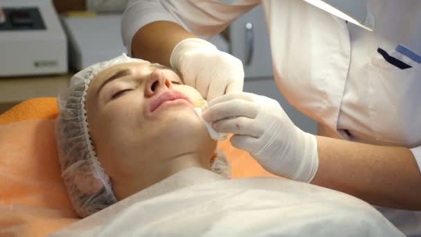 Clinique de beauté. Mains d'esthéticienne dans des gants faisant l'injection de vieillissement du visage dans une peau féminine. Une femme obtient la procédure de cosmétologie faciale beauté. Botox. injections de collagène. Tourné en 4k — Video