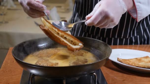 レストラン料理のコンセプトです。手袋でシェフのキャラメルでフランベ パンケーキを調理します。スローモーション. — ストック動画