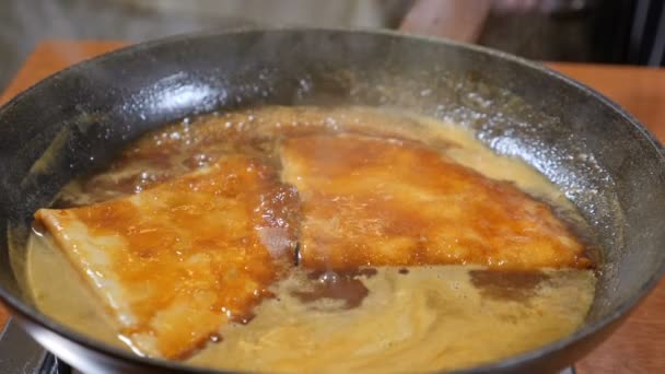 Concept de cuisine restaurant. Chef en gants cuisinier crêpes flambe au caramel. Mouvement lent . — Video