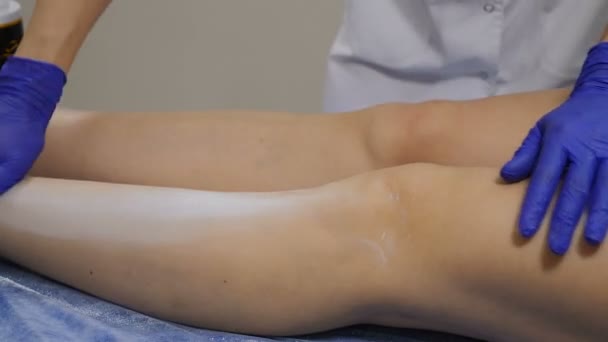 L'estetista spteads la polvere igienica su gambe prima di procedura di rimozione di capelli. Girato in 4K. Close up — Video Stock