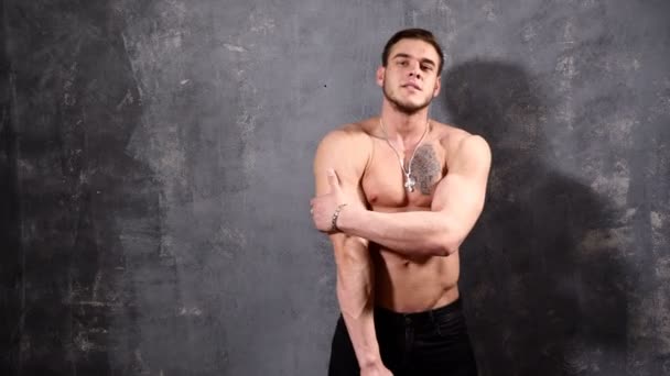 Kräftiger und muskulöser Bodybuilder, der posiert und seine Weste aufreißt. perfekte Sixpack Bauchmuskeln eines muskulösen jungen Mannes — Stockvideo