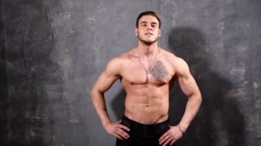 Güçlü ve kas adam vücut geliştiricisi. Adam siyah bir arka plan üzerinde poz güzel Abs ve göğüs kasları kasları gösterir.