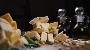 Restoran sanat kavramı. Farklı türlü peynir yığın siyah arka plan üzerine koyun. Çam fıstığı ağır çekimde avuç