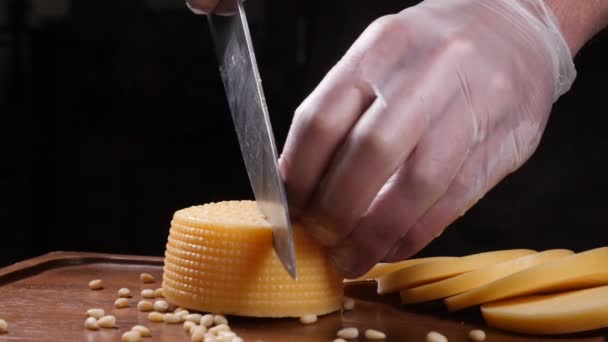 Chef-kok in handschoenen plakjes kaas met een mes. Restaurant. Tabel serveren. Voedsel kunst — Stockvideo