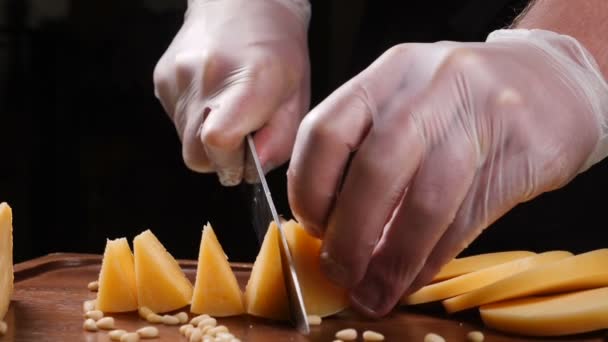 Chef en guantes corta queso con un cuchillo. Restaurante. Mesa de servir. Arte alimentario — Vídeos de Stock