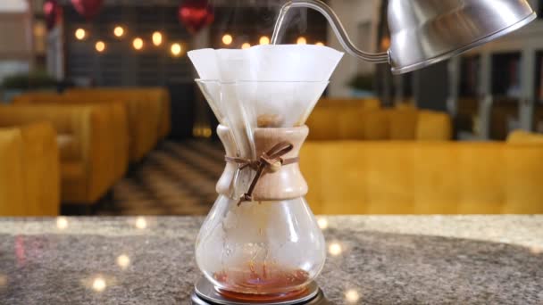 コーヒーの近代的な代替方法です。バリスタ ビール コーヒー コーヒー メーカーを使用しています。コーヒーのペーパー フィルターにお湯を注いで手のクローズ アップ。スローモーション — ストック動画