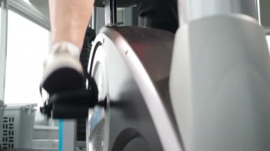 Son sınıf kadın spor salonunda bisiklet çeviriyor. Bisiklet egzersizi sırasında çekilen kadın bacaklarını kapat. Yakın plan. Ayak dönme pedalı ve statik bisiklet jimnastiği. 4K 'da çekilmiş.