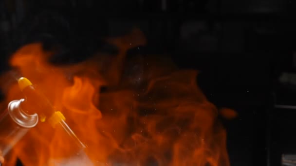 Flames burn out of frying pan on black background. Open yellow fire at restaurant kitchen. Cognac is ignited in girdle. slow motion. Shot in hd — Stock Video