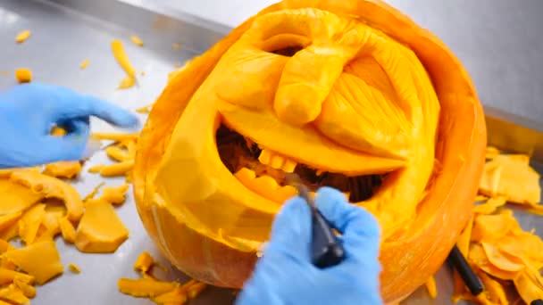 Manos femeninas tallar calabaza para la celebración de Halloween. En cámara lenta. Artista irreconocible. Fiestas americanas. Preparación del Día de las Reliquias. Primer plano. 4k — Vídeo de stock