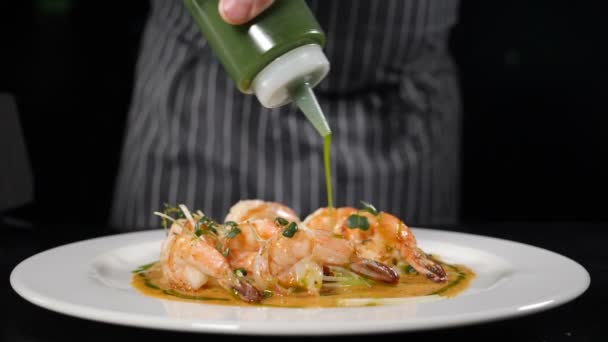 Ιταλική κουζίνα. σεφ ρίχνει σάλτσα σε γαρίδες dishvplaced σε λευκό πιάτο, Νόστιμη και νόστιμα σπιτική κουζίνα, μενού εστιατόριο έτοιμο να εξυπηρετήσει, υγιεινή διατροφή έννοια. Αργή κίνηση. hd — Αρχείο Βίντεο
