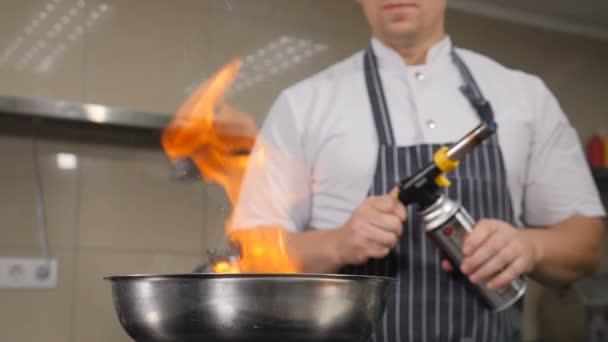 Cocina de chef en la cocina del restaurante. Cocinar con llama, imágenes en cámara lenta de llamas saliendo de la sartén. Hd — Vídeos de Stock