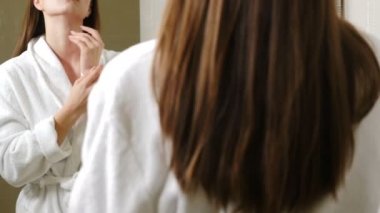 Sabahları bornozlu genç bir kadının aynada kendine baktığını görüyorum. Yüzünde ve saçlarında doğal bir gülümseme olan, kendine güvenen ve görünüşünden tatmin olan tatlı bir kadın. Vuruldu.