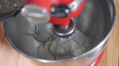Tatlı pişirme süreci. Ağır çekimde karıştırıcıyla beyaz krem şanti. Pasta yapmak için lezzetli kremayı karıştıran stand mikserine yakın çekim. Elektronik karıştırıcı krema malzemelerini karıştırıyor. hd