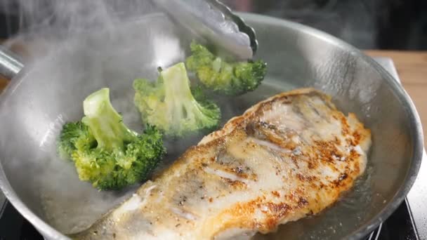 Şef, sebze otları pişirirken ateş kullanır. Restorandaki modern mutfakta brokoli, ızgarada sebzeler, gaz ocağı. Ağır çekimde yakın çekim. Yüksek çözünürlüklü çekim — Stok video
