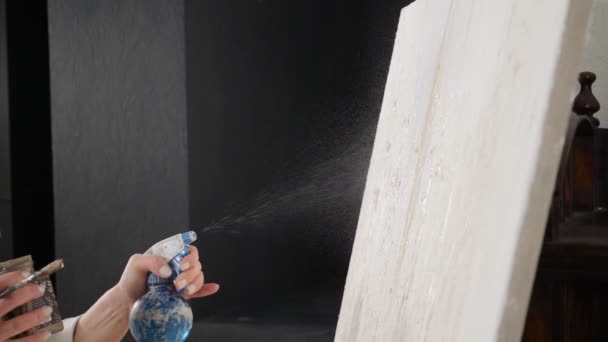 Mujer artista pintando con pincel y acuarela hidratante sobre lienzo blanco en taller de arte estudio. cámara lenta. De cerca. Disparo en hd — Vídeo de stock