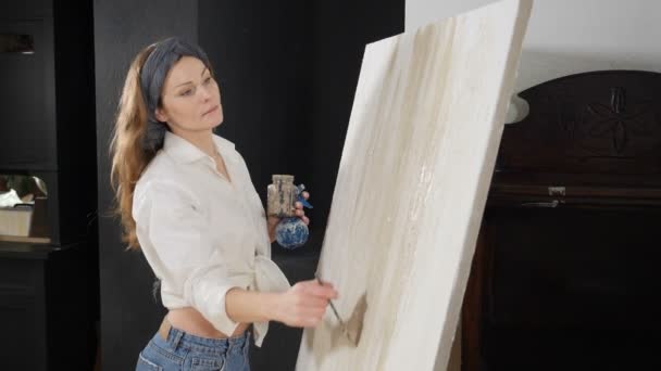 Artiste féminine sérieuse travaillant à l'image avec des peintures à l'huile et la création d'image abstraite sur toile. Technique de peinture et les peintres et les gens de l'art concept. Au ralenti. Tourné en HD — Video