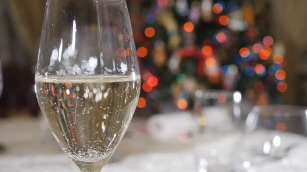 Verser le champagne au ralenti avec des lumières de Noël floues, guirlande clignotante en arrière-plan. Fête de Noël et Nouvel An. Cadre de table, concept de décoration. Tourné en HD — Video