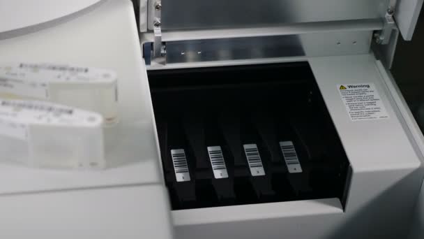 Equipamento de laboratório de teste de sangue e dna moderno. Close-up de especialistas colocando cartuchos em rack para ser colocado no dispositivo de análise médica. Equipamento médico moderno para pesquisa genética. 4k — Vídeo de Stock