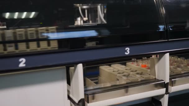 ヒトのDNAや血液分析のための自動機械のラック内の血液サンプル、実験室機器の概念。4kで撃たれた — ストック動画