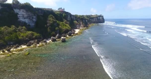 水しぶきと白い泡で岩の崖にクラッシュ紺碧の海と波の息をのむような空中ビュー。インドネシアのバリ島。4kで撃たれた — ストック動画