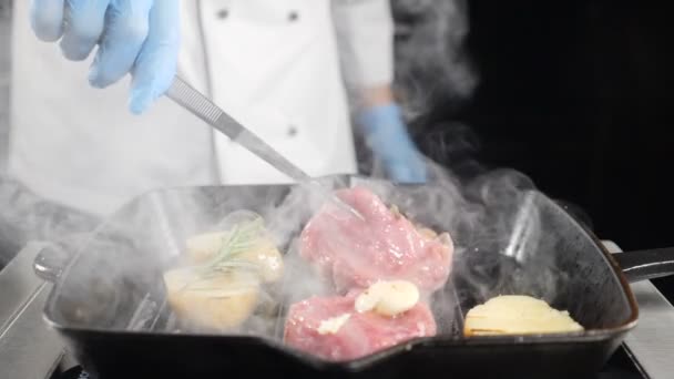 Proces vaření různých lahodných jídel v oblíbené luxusní restauraci. Šéfkuchař smaží brambory a maso na griddle. Zpomal. hd video — Stock video