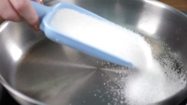 Karamel pişirmek için tavaya şeker dökmek. Restoran yemekleri konsepti. Ağır çekim. hd video