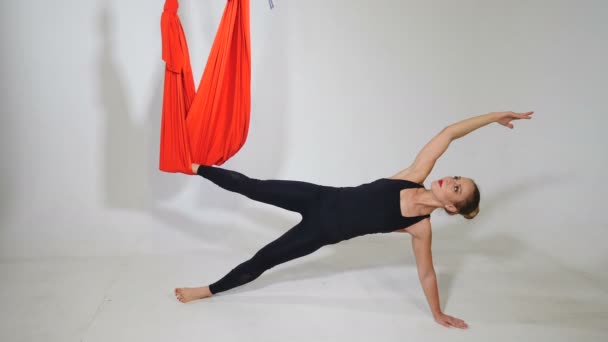 Fly jóga ion bílé pozadí. Životní styl a sport. Yong sportovní žena provádí fyzická cvičení pro vzduch jóga, pilates, regenerační zdraví. Shot in 4k — Stock video