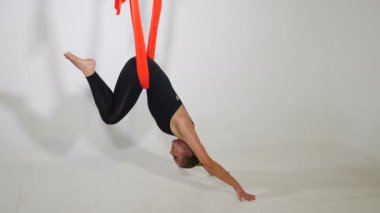 Spor sağlıklı yaşam tarzı konsepti. Siyah spor giysili güzel bir kadın. Sinek yogası yapıyor. Spor salonunda esneme egzersizleri yapıyor. 4k görüntü